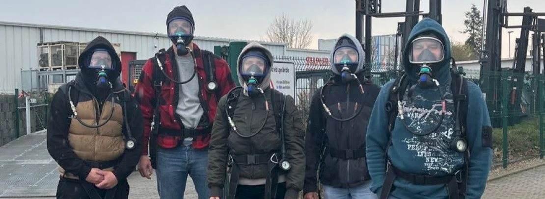 5 personen mit atemschustz maske stehen vor gebäude